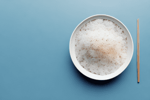 A bowl of cooked rice with a smartphone placed on top