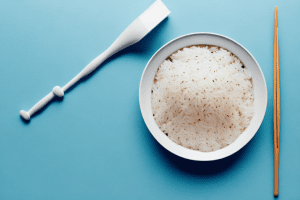 A bowl of rice with a cloth and scrubbing brush beside it