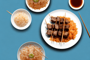 A plate of beef skewers with teriyaki glaze and fried rice