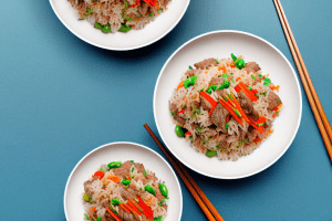 A bowl of beef and vegetable fried rice with chopsticks