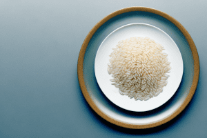 A plate of steaming rice with a bull-shaped design made of garlic slices