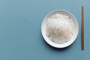 A bowl of cooked rice with a spoon and fork beside it