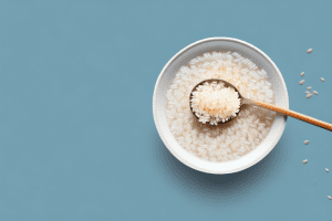 A bowl of steaming hot rice milk with a spoon and a few grains of rice scattered around it