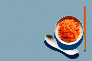 A bowl of tomato-flavored rice with a spoon beside it